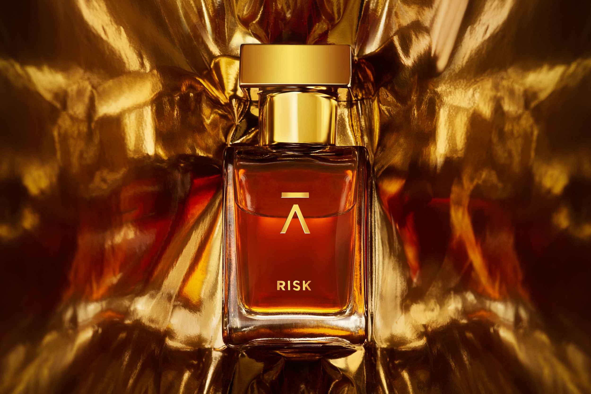 Azman Risk Perfume collaboration with Italian perfumer Antonio Gardoni. Majnoon bottle features a long neck, hand-polished bottle with a heavy gold metal cap. The packaging includes a side-opening heavy cardboard box adorned with a gold foil Azman logo. Azman Risk perfume bottle is shot in dramatic gold foil to gives ultra stylish effect. The whisky gold color of the Risk perfume adds a touch of luxury and sophistication.