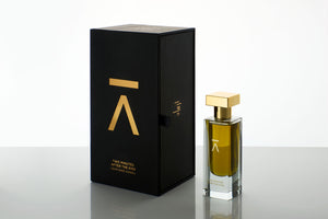 Azman Perfumes, crafted by the award-winning Zoologist Bee Perfumer Cristiano Canali. Studio-shot perfume bottle and black against a crisp white background, showcasing warm green liquid. The tall, slender bottle features a runway model like long neck, adorned with a luxurious heavy gold metallic cap, enhancing the allure of the presentation and the perfume's name.