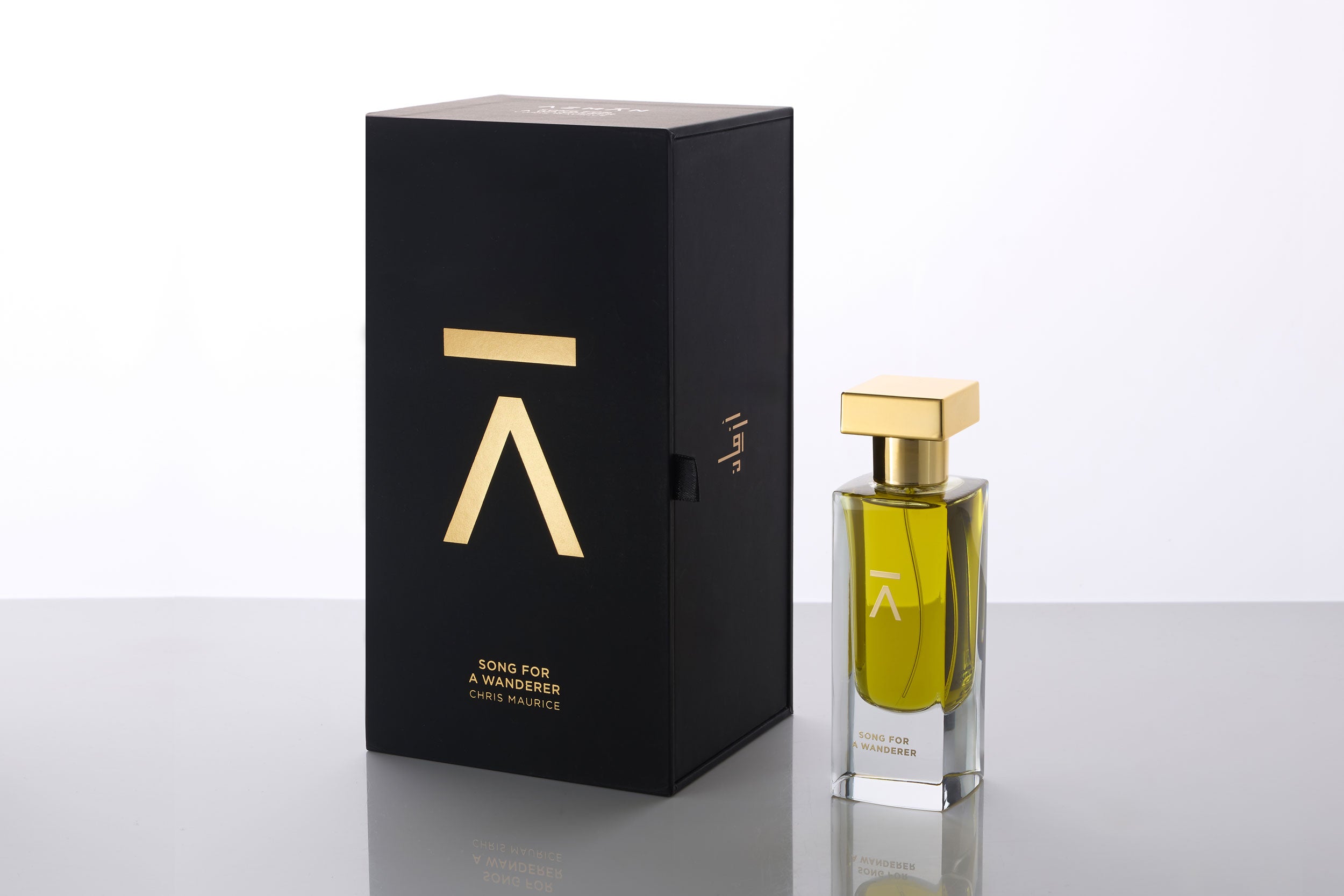 Studio photograph of a ‘Song For A Wanderer’ perfume bottle by Azman Perfumes in collaboration with Chris Maurice, set against a white background. The bottle reflects a green yellow, fresh, and mysterious aesthetic, highlighting elements such as smoke, wet land, jasmine, bergamot and oud.