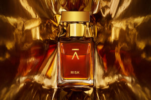 Azman Risk Perfume collaboration with Italian perfumer Antonio Gardoni. Majnoon bottle features a long neck, hand-polished bottle with a heavy gold metal cap. The packaging includes a side-opening heavy cardboard box adorned with a gold foil Azman logo.  Azman Risk perfume bottle is shot in dramatic gold foil to gives ultra stylish effect. The whisky gold color of the Risk perfume adds a touch of luxury and sophistication.