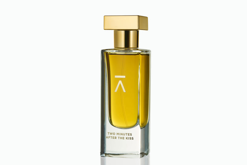 Azman Perfumes, crafted by the award-winning Zoologist Bee Perfumer Cristiano Canali. Studio-shot perfume bottle against a crisp white background, showcasing warm green liquid. The tall, slender bottle features a runway model like long neck, adorned with a luxurious heavy gold metallic cap, enhancing the allure of the presentation and the perfume's name.