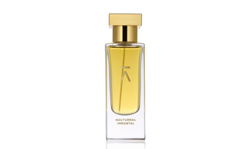 Studio photograph of the ‘Nocturnal Immortal’ perfume bottle by Azman Perfumes, created in collaboration with Julien Rasquinet. Set against a white background, the bottle reflects a woody, oriental, and mysterious aesthetic. The perfume features key notes of Fir Balsam Absolute, Orange Bitter Oil, Cistus Labdanum, Vetiver Oil Haiti, and Hay Absolute, embodying a rich and natural essence.